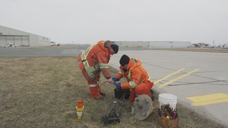 Toronto Pearson Electricians, John Kis and Chris MacDonald search for a fault on a lighting circuit on Taxiway Kilo.  (Arrow International Media Ltd & Cantina Media)