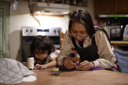 Louise Moses sews a hat for one of her children. (National Geographic/Wayne Shockey)