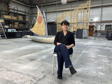 Set designer Milagros sits in front of the set pieces she designed for the Disney Treasure's new stage production, "Disney The Tale of Moana." (credit: National Geographic/Mirella Pappalardo)