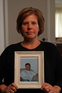 Denise Santille holds a photo of her half-brother Michael Leach. (National Geographic/Andrew Thompson)
