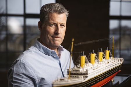 Chris Hearn stands with a model of RMS Titanic. (National Geographic/Freddie Claire)