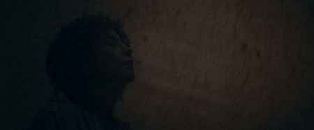 Julia Felix, played by Lubna Azabal, lifts her face to the sky muttering prayers to the Goddess Isis to save them, as volcanic ash rains down around her. (National Geographic)