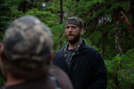 Oliver Johnson gets a lesson in logging from his experienced neighbor. (National Geographic/Lukas Taylor)