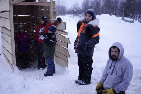The Strassburg family helping each other put wood away for winter in their wood shed. (National Geographic/Wayne Shockey)