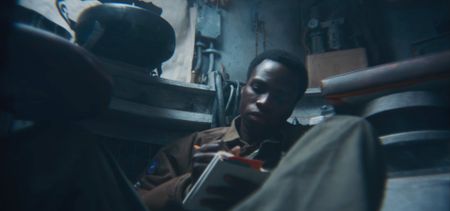 Staff Sergeant Johnnie Stevens (played by Juwon Adedokun) writes in his diary on Nov. 8, 1944, in Vic-sur-Seille, France, in a historic reenactment of the Battle of the Bulge produced for "Erased: WW2's Heroes of Color." Staff Sergeant Stevens was a tank commander with the 761st Black Panther Tank Battalion who served in WW2. (National Geographic)