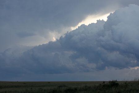 A thick, continuous cloud rolls across the landscape in Maasai Mara, Kenya. (National Geographic/Joe Treddenick)