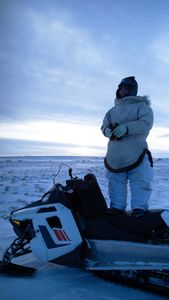 Agnes Hailstone glasses for caribou on top of her snowmobile. (BBC Studios Reality Productions, LLC/Ashton Hurlburt)