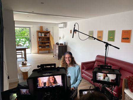 In front of cameras, big wave surfer Justine Dupont is being interviewed.  (National Geographic/Gene Gallerano)