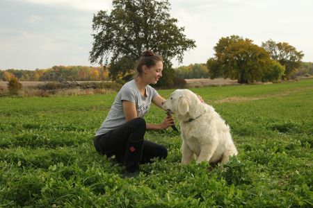 Beth Pol brushes Clovis', the Pol family's new dog, chin hair after he walks out of a bush at the Pol family's farm. (National Geographic)