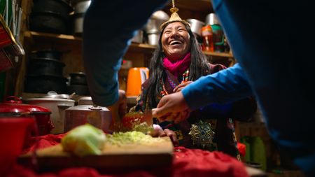 Aum Passang laughs as Will Smith prepares food.  (credit: National Geographic)