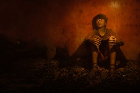 Avianius, played by Frankie Treadaway, sits against a wall on a street in Pompeii, his eyes wide with fear and desperation as he struggles to navigate and find his mother in the choking ash. (National Geographic/Darrin Zammit Lupi)