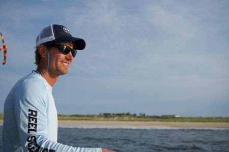 Capt. Greg Metzger fishes for menhaden early in the morning, the baitfish used to catch baby white sharks. (National Geographic/Brandon Sargeant)
