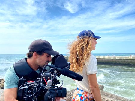 Facing the pier, right next to the water, big wave surfer Justine Dupont admires the sea, as DP Alfredo de Juan films her from behind.  (National Geographic/Gene Gallerano)