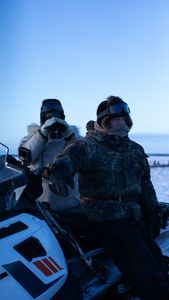 Chip and Agnes Hailstone glass the tundra for a herd of caribou passing through during their migration. (BBC Studios Reality Productions, LLC/Ashton Hurlburt)