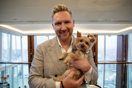 Kurt Macher, the general manager at the Shangri La, poses with his dog Rocky in the hotel reception. (National Geographic/Richard Ing)