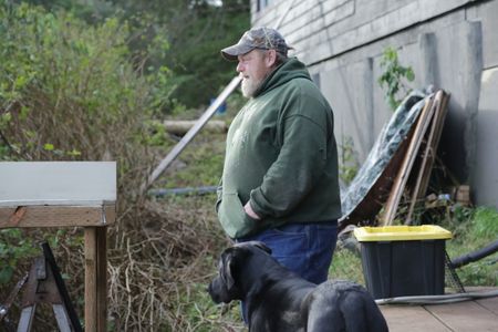 After a successful deer hunt, Tim 'Curly' Leach plays with his dog Junior. (National Geographic/Mickey Ramos)