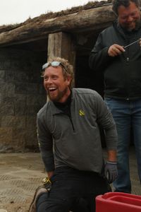 Ben Reinhold and Charles Pol laugh while finishing up the sheep hut's new concrete floor. (National Geographic)