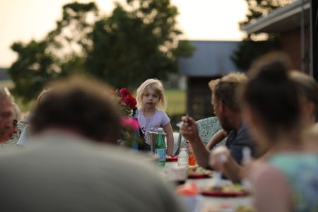 Silas Pol, Charles and Beth's son, puts his fingers in his food-covered mouth at the family's barbecue. (National Geographic)