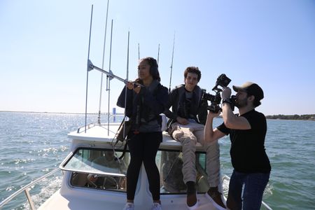 BTS of students Beckham La Rose and Kaelyn Heits using tracking equipment on board boat. (National Geographic/Mariana Kneppers)