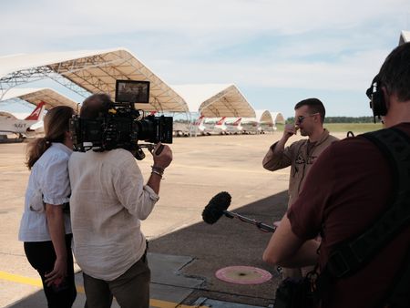 Director Lana Salah, DOP Jon Southgate-Sayers, student LTJG Andrew Seepe, and sound recordist Phil Bax out on the flight line. (Credit: National Geographic/Freddie Claire)