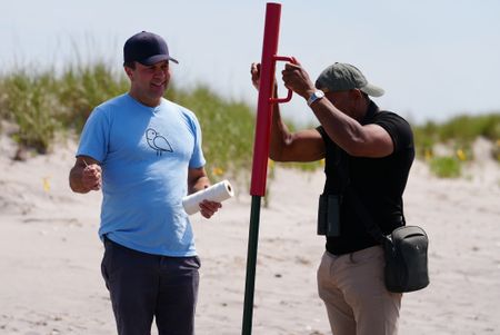 NYC Plover Project founder Chris Allieri and Christian Cooper set up symbolic fencing to protect piping plover nests at Fort Tilden. (National Geographic/Troy Christopher)