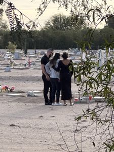 Joseph Robin, Michelle Harrison, and Tajia Robin visit Melody Harrison's grave. (National Geographic/Tom Beard)