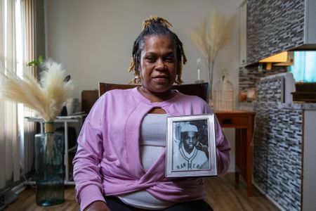 Lenette Smith, eldest sister of the doe, holds a photo of her brother, Kaif Bismillah (birth name Keith Lavell Bibbs). (National Geographic/Tom Beard)