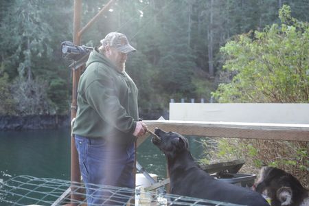 After a successful deer hunt, Tim 'Curly' Leach plays with his dog Junior. (National Geographic/Mickey Ramos)