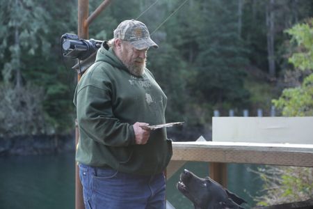 After a successful deer hunt, Tim 'Curly' Leach plays with his dog Junior. (National Geographic/Mickey Ramos)
