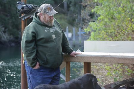 After a successful deer hunt, Tim 'Curly' Leach plays with his dog Junior. (National Geographic/Mickey Ramos)