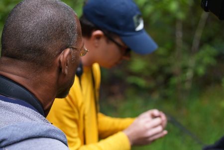 Christian Cooper watches avian technician Bret Nainoa Mossman release a bird from a mist net at the Pu'u Maka'ala Natural Area Reserve. (National Geographic for Disney/Troy Christopher)