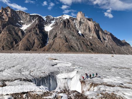 The team look into a vast hole in the ice called a moulin. (photo credit: National Geographic/Pablo Durana)