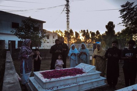 Amir Waseem, Tahira Perveen and other family members gather at the gravesite of Chaudry Wali Mohammad at his family home in Rawalpindi, Pakistan. Corporal Chaudry Wali Mohammed was a member of Force K6, an Indian Regiment of mule handlers in WW2. Amidst the chaos of Dunkirk and the advancing German Army, one little-known Indian Regiment fights for victory and independence. (National Geographic/Daniel Dewsbury)