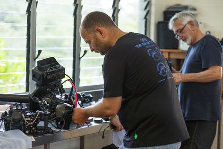Camera assistant, Woody Spark, preparing cameras and underwater housings with cinematographer Rory McGuinness.  (National Geographic for Disney/Harriet Spark)