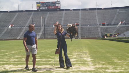 Christian Cooper assists rator trainer, Amanda Sweeney, with Independence's pre-gameday flight practice. (National Geographic for Disney)