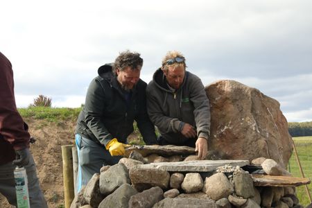 Charles Pol and Ben Reinhold stack rocks and stone to create a natural looking waterfall for the Pol family farm's new pond. (National Geographic)