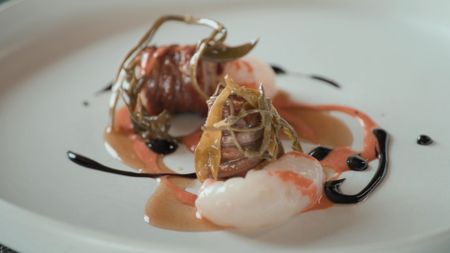 Torcinello, a traditional sausage, served with scampi, sea asparagus, and sweet pepper sauce.  (credit: National Geographic)