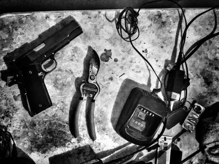 Sinaloa table with phone charger wire cutter and pistol. (Nick Quested)