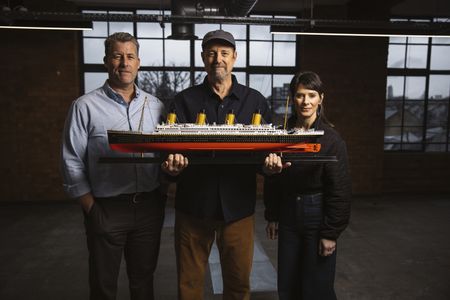 Chris Hearn, Parks Stephenson, and Jennifer Hooper stand with a model of RMS Titanic. (National Geographic/Freddie Claire)