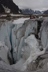 Team on the edge of a moulin.  (photo credit: National Geographic/Matt Pycroft)