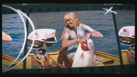 Valerie Taylor in boat holding up large fish, 1965. (photo credit: Ron & Valerie Taylor)