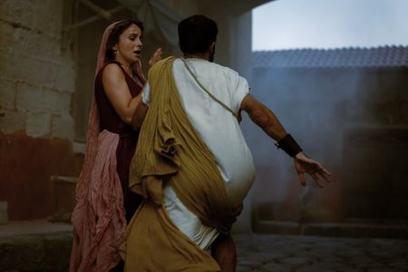 A panicked man runs towards Claudia, played by Madeleine Walker, nearly knocking her over as Mt. Vesuvius begins to erupt. (National Geographic/Darrin Zammit Lupi)
