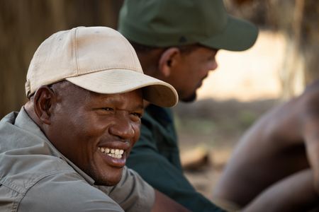 San Bushman Guide Kane Motswana, left, and Will Smith talk with the San people in the Kalahari Desert. (credit: National Geographic/Kyle Christy)