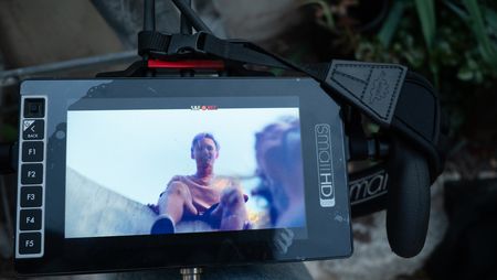Johnny Collinson watches Angel Collinson jump on the trampoline, which is shown on the director's monitor.  (National Geographic/Elena Gaby)
