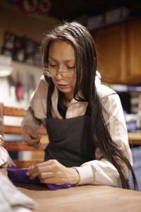 Louise Moses sews a hat for one of her children. (National Geographic/Wayne Shockey)