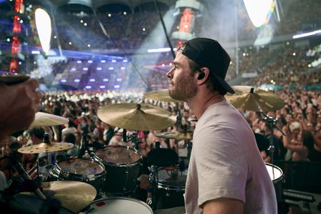 Chris Hemsworth drums during the Ed Sheeran concert in Bucharest. (credit: National Geographic/Evan Paterakis)