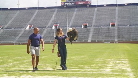 Christian Cooper assists rator trainer, Amanda Sweeney, with Independence's pre-gameday flight practice. (National Geographic for Disney)