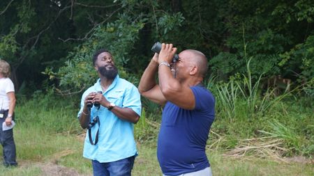 Christian Cooper and Cristopher Joe watch the swallow-tailed kites dance in the air above the freshly-mowed hay fields. (National Geographic for Disney)