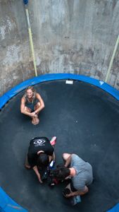 Angel Collinson smiles on the trampoline as cinematographer Nick Kraus and assistant cameraperson Galen Murray change a lens.   (National Geographic/Elena Gaby)