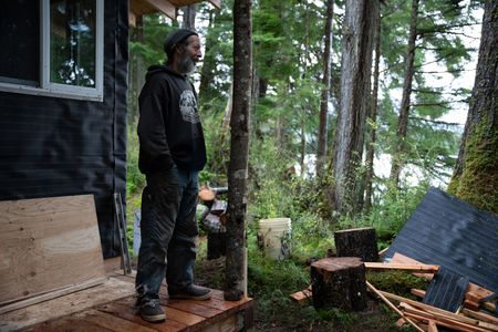 Dave Palmer helps build a cabin for his friend. (National Geographic/Robert Jolley)